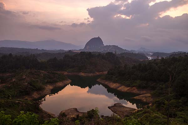 view of rock lake and hills surrounding guatape