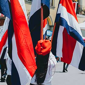 A woman carrying a flag in a procession on Independence Day in Costa Rica