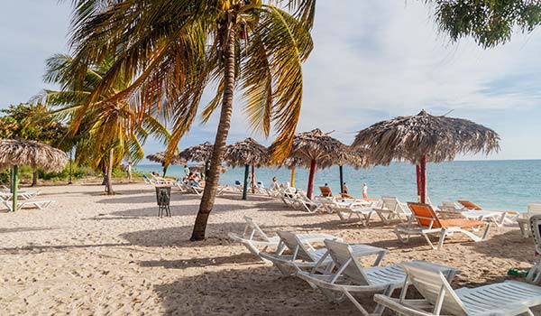 playa ancon is one of cubas best beaches with umbrellas sun loungers and palm trees