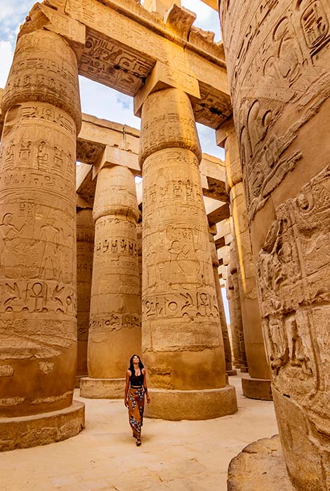 woman walking around egyptian ruins exploring on a group tour in egypt