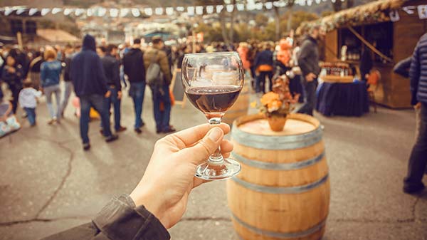 person holding a glass of georgian red wine at a wine festival in georgia