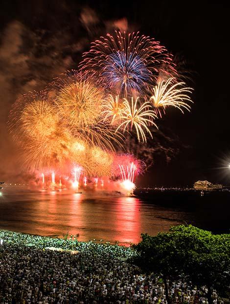 crowd of people watching a fireworks display over the lake in Iceland on the twelfth night