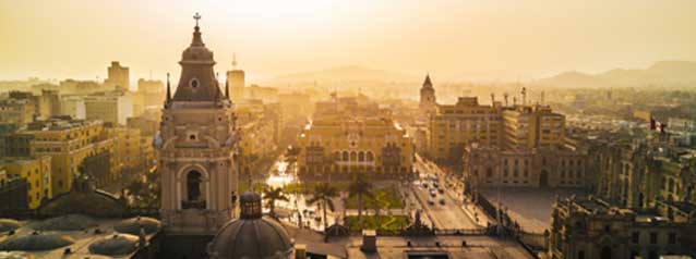 adventue holiday tour group in lima from an aerial view looking down onto the historic square of plaza de armas at sunset