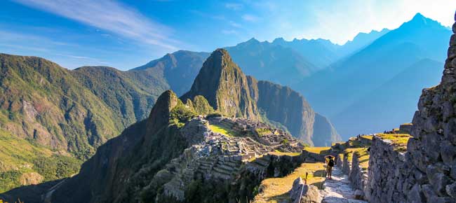 Machu Picchu honeymoon couple on holiday are exploring the ancient ruins of machu picchu in perfect weather conditions