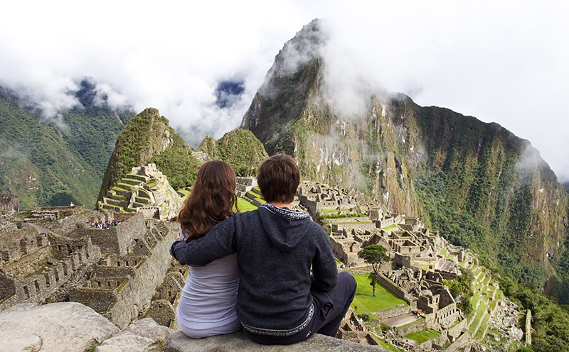 couple on honeymoon sitting in front of Machu Picchu