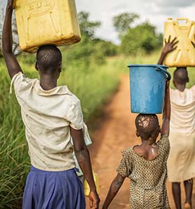 group of young people carrying water in uganda