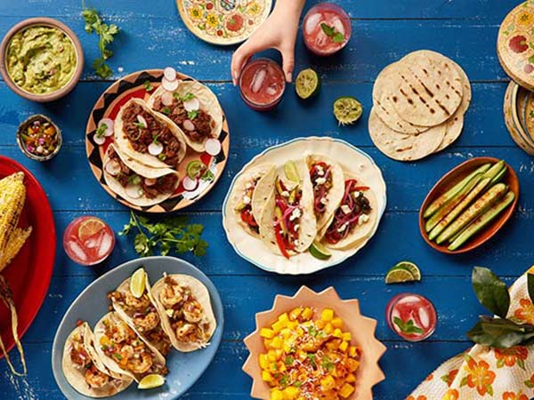 table spread of traditional mexican food on a blue wooden table