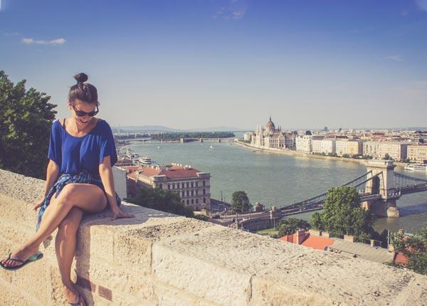 single traveler in awe of her surroundings an amazing background of the Danube River and Budapest skyline in Hungary