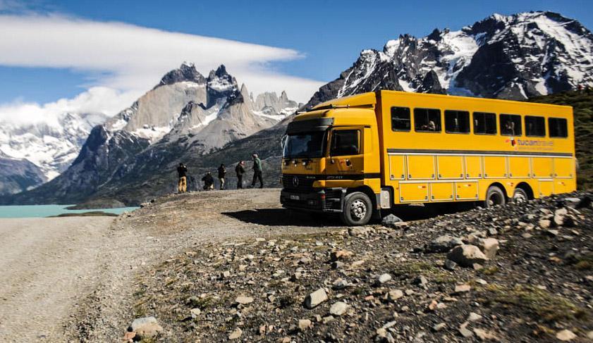 The yellow Tucan Travel truck parked up as the travellers soak in their surroundings