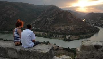 A couple admires the merging of the Aragvi and Kura rivers from the viewing point of the Jvari Monastery near the town of Mtskheta in Georgia